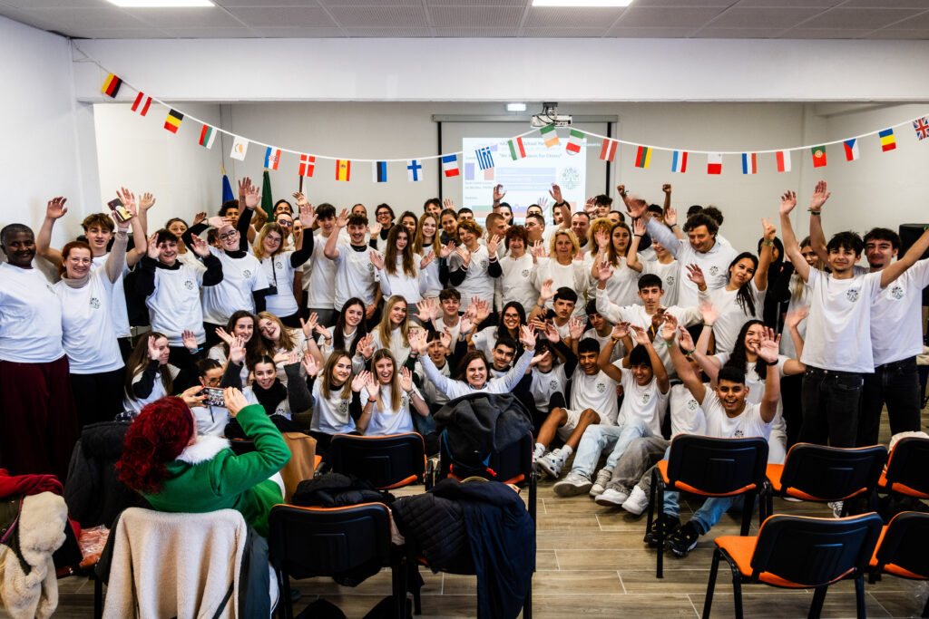 Group photo of the young Erasmus students at the Cartaixo secondary school, arms raised. 
Portuguese high school: ‘Agrupamento de Escolas Marcelino Mesquita do Cartaxo(AEMMC)’.